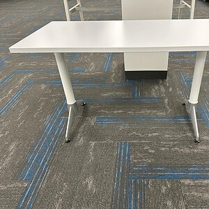 Bright white rectangular table with sturdy steel legs, ideal for office or conference room settings.