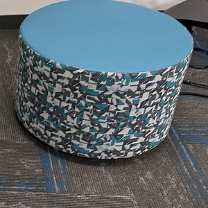 Blue patterned round ottoman for modern living spaces.