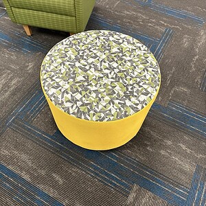 OFS yellow patterned round ottoman with geometric fabric top, perfect for modern living spaces.