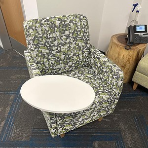 OFS green patterned lounge chair with tablet arm, perfect for modern office or lounge spaces. Stylis.