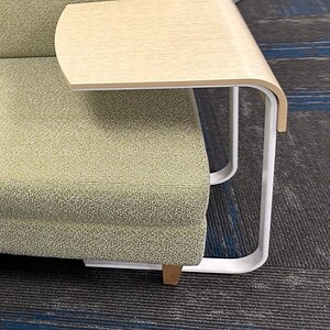 Maple veneer side table attached to a green upholstered chair for laptops or work.