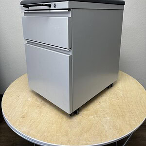 Herman Miller mobile pedestal with grey cushion top, ideal for office storage and organization.
