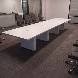 Modern 16-foot white powered conference table in office setting.