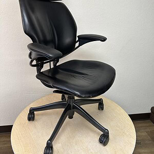 Ergonomic Humanscale Freedom leather office chair with headrest, black, adjustable for comfort.