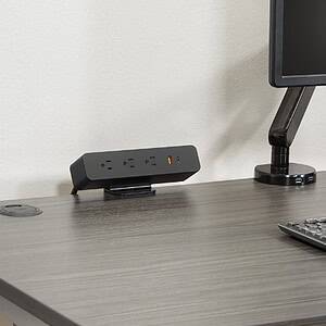 Power charger clamp-mount with multiple outlets on a modern office desk.