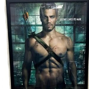 Arrow movie poster featuring a shirtless male character with a bow and arrows.