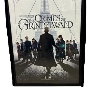 The Crimes of Grindelwald movie poster with characters and dark background.
