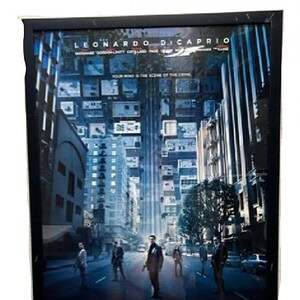 Inception movie poster framed for display, featuring Leonardo DiCaprio in a cityscape scene.