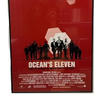 Ocean's Eleven framed movie poster, 27x40 inches, featuring the main cast in a stylish red backgroun.