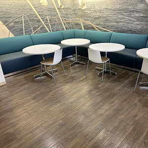 Teal and blue Gunlocke modular banquet with round tables and chairs on a boat deck.