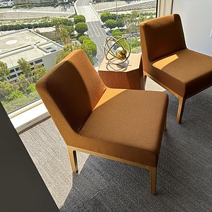 Keilhauer Saddle Brown lounge chairs with wood legs in modern office space.