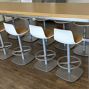 Post Stool with white seat and brown cushion, modern design for office or lounge areas.