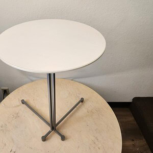 Laptop table with white round top and black metal legs, perfect for modern workspaces.