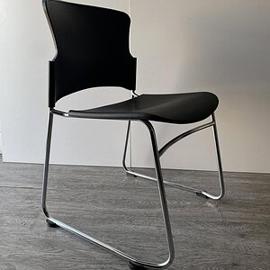 Black Boss Stack chair with steel frame, ideal for office or conference rooms.