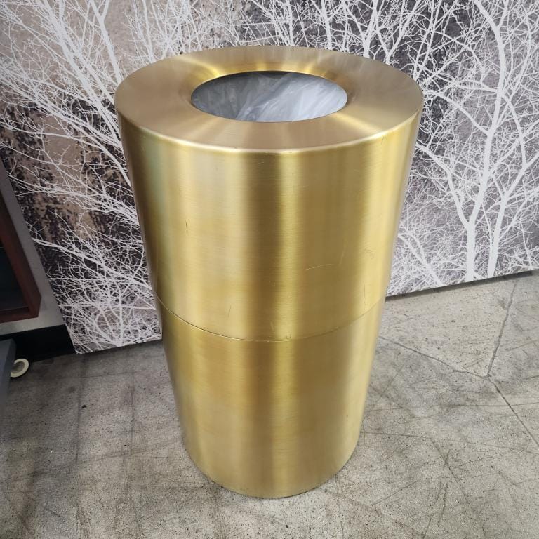 Gold commercial trash can with a sleek design for public spaces.