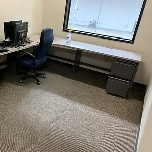 Herman Miller 8x8 desk with two grey pedestals and office supplies.