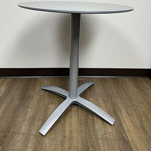 Round steel table for modern office or dining spaces. Durable, sleek design perfect for versatile us.