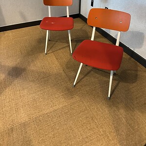 Stylish red and orange Barcelona chairs with white metal legs for modern interior decor.