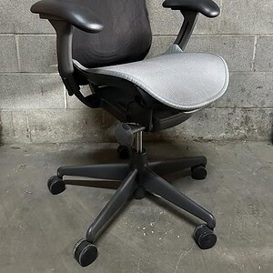 Herman Miller Mirra chair with graphite frame, tilt, and adjustable arms.