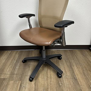 Office chair with beige mesh back and brown leather seat.