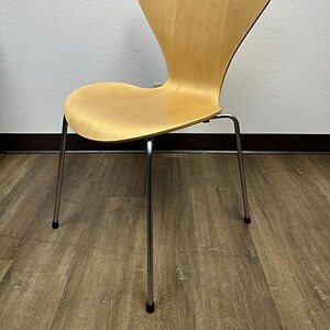 Arne Jacobsen Maple Series 7 chair with wooden seat and metal legs.