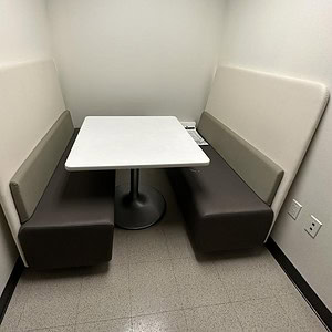 Modern neutral-colored banquet sofa with table for lounge or meeting areas.