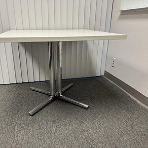 Herman Miller metallic table with 30-42 inch top, modern office furniture.