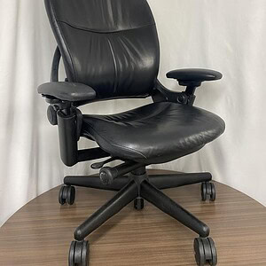Office chair with black leather upholstery, adjustable armrests, and ergonomic design. Perfect for p.