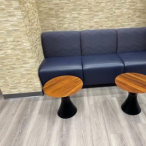 Blue banquet seating with two wooden side tables in a modern lounge setting.