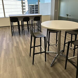 Contemporary office space with high-top tables and bar stools in a bright, urban setting.