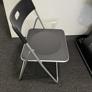 Foldable gray chair for versatile seating solutions.