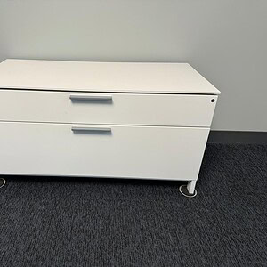 Herman Miller white low credenza with 2 drawers for office storage.
