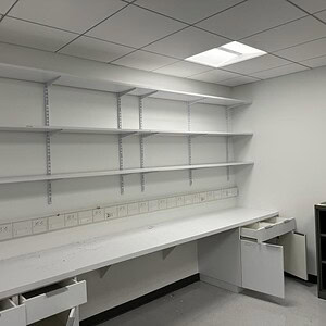 Wall mounted white overhead desk shelves for organized workspace storage.