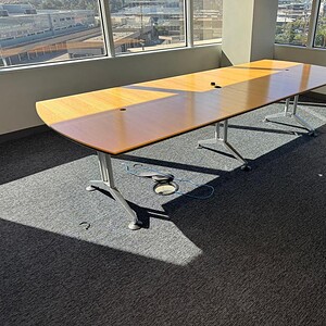 Modern Herman Miller 10x4 veneer conference table in bright office space.