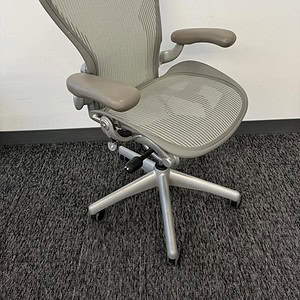 Aeron ergonomic office chair with titanium finish and dual paddle adjustment.