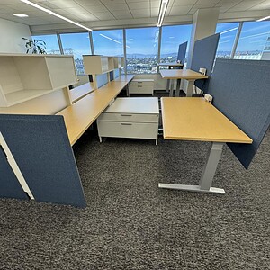 Adjustable Herman Miller desk with privacy panels and spacious workspace. Perfect for ergonomic offi.