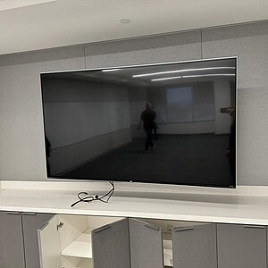 Mounted LG 79-inch TV in a modern conference room.
