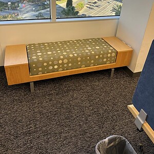 Bench with Maple wood finish and patterned sage upholstered cushion, ideal for office or lounge seat.
