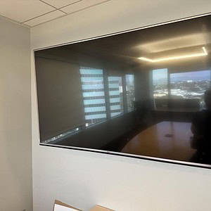 LG 65 inch TV mounted on the wall in a modern office setting.