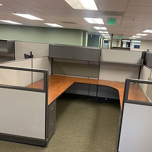 Office cubicles with cherry wood and glass panels for modern workspace design.