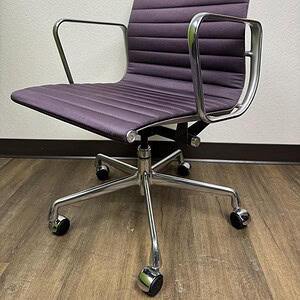 Vintage Herman Miller Eames office chair in violet with chrome armrests and base.