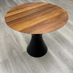 Modern round table with wooden top and black pedestal base, ideal for contemporary interiors.