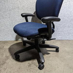 Navy blue and black Haworth Improv H.E. office chair with adjustable armrests and ergonomic design.