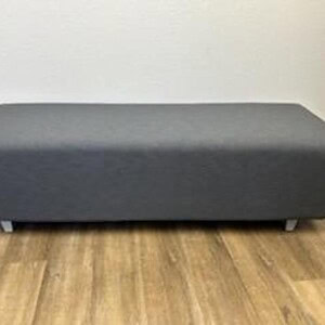 Ottoman bench in grey plush fabric, ideal for living rooms or offices.
