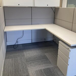 Cubicle workstation with tall panels and built-in desk for office privacy.