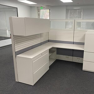 Modern office workstation with white cabinets and cubicle dividers.