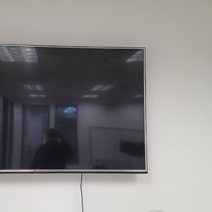Samsung 46-inch TV mounted on wall in a modern conference room.