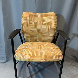Comfortable stacking chair with patterned fabric and black metal frame, ideal for events and confere.