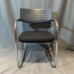 Vitra chair with perforated backrest and cushioned seat, modern office furniture.