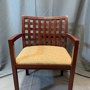 Guest chair with wooden frame and cushioned yellow seat for comfort and style.